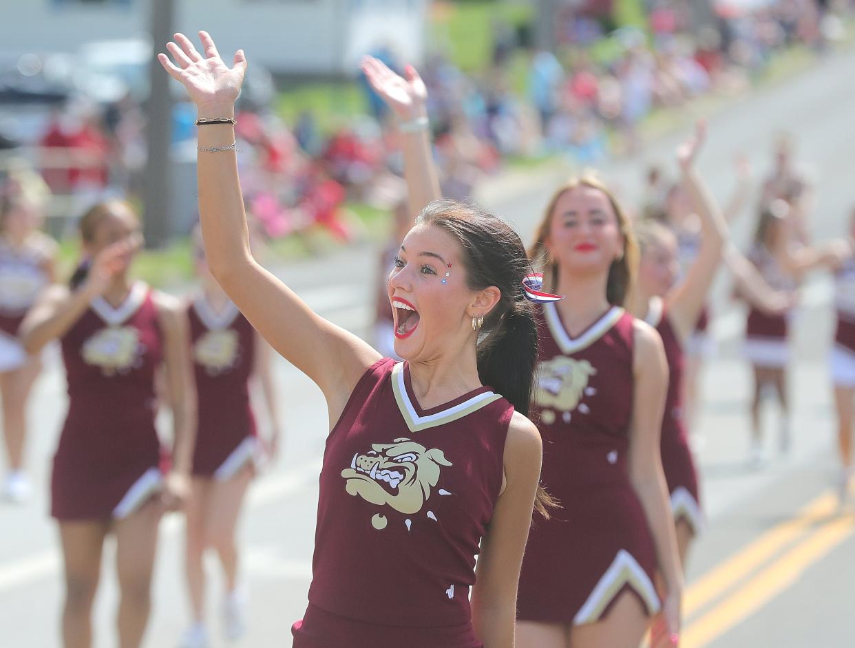 Stow High School senior cheerleader Sophia Casterline gives an enthusiastic wave to a familiar face in the crowd during the 64th annual Stow Parade on Tuesday, July 4, 2023 in Stow. The city made Zillow's list of Top 10 communities in 2023.