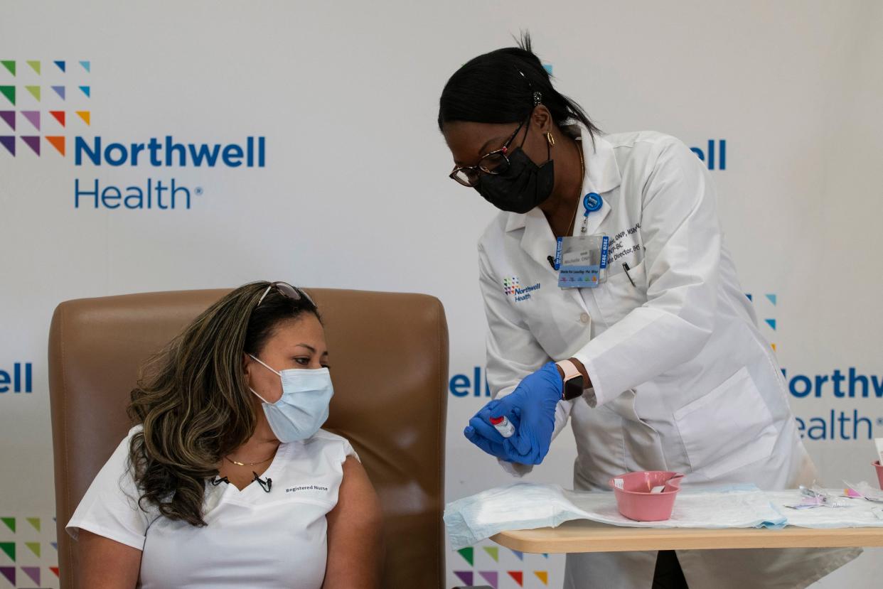 <p>A woman is administered with the vaccine by a medical professional at Northwell Health</p> (ASSOCIATED PRESS)