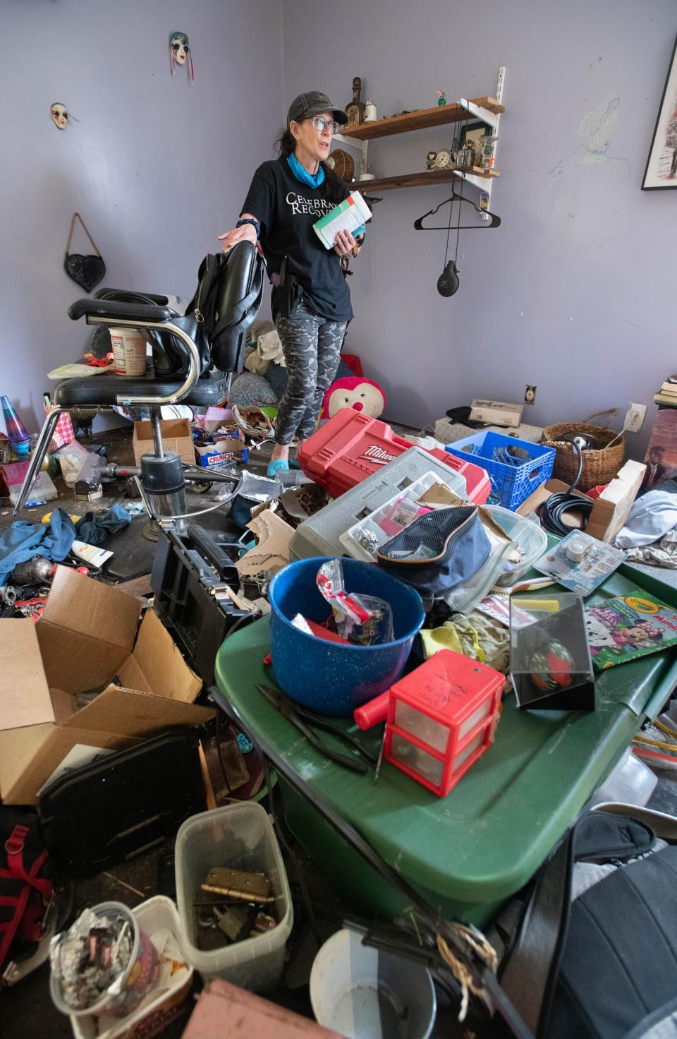 Carrie Black-Phillips surveys trash and what she believes is drug paraphernalia left by squatters in the house owned by her family on Tom Sawyer Road in Milton on Tuesday, Feb. 27, 2024. Her family is trying to clean up the mess left by the squatters and are battling to keep them off the property.