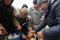 Local residents wait to get free bread from volunteers in Bakhmut, the site of the heaviest battle against the Russian troops in the Donetsk region, Ukraine, Friday, Oct. 28, 2022. (AP Photo/Efrem Lukatsky)