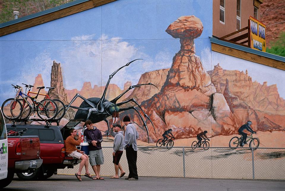 Cyclists take a break in front of a mural in Moab, Utah.