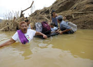 <p>Marta Sostre Vazquez reacts as she starts to wade into the San Lorenzo Morovis river with her family, after the bridge was swept away by Hurricane Maria, in Morovis, Puerto Rico, Wednesday, Sept. 27, 2017. The family was returning to their home after visiting family on the other side. (Photo: Gerald Herbert/AP) </p>