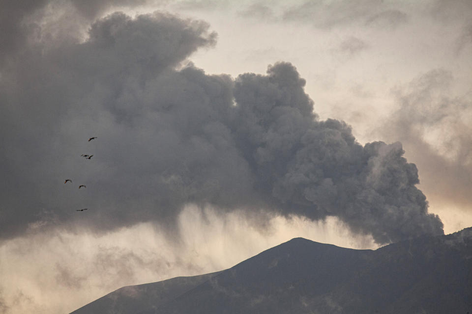 Mount Marapi spews volcanic materials during its eruption as seen from Tanah Datar, West Sumatra, Indonesia, Friday, Dec. 22, 2023. Volcanic ash spewing from the nearly 2,900-meter (9,480-foot) volcano shut down airports and blanketed nearby communities on Sumatra island Friday. (AP Photo/Ali Nayaka)