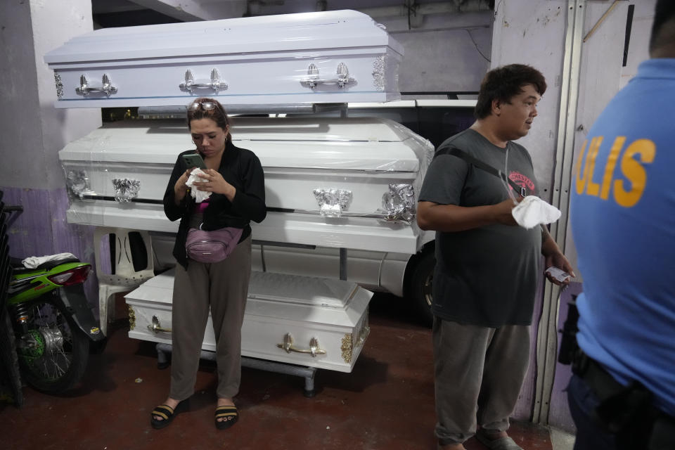 Filipino relatives wait at a mortuary in Silang, Cavite province, south of Manila, Philippines on Thursday, July 11, 2024. Two Australian nationals and their Filipina companion were killed at the Lake Hotel and police efforts were underway to identify and track down suspects, officials said. (AP Photo/Aaron Favila)