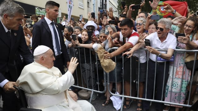 Pope Francis waves to the crowd as he arrives.