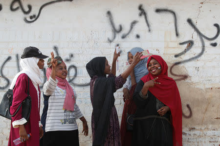 Sudanese demonstrators make victory signs and take selfies during a protest in front of the Defence Ministry in Khartoum, Sudan April 17, 2019. REUTERS/Umit Bektas