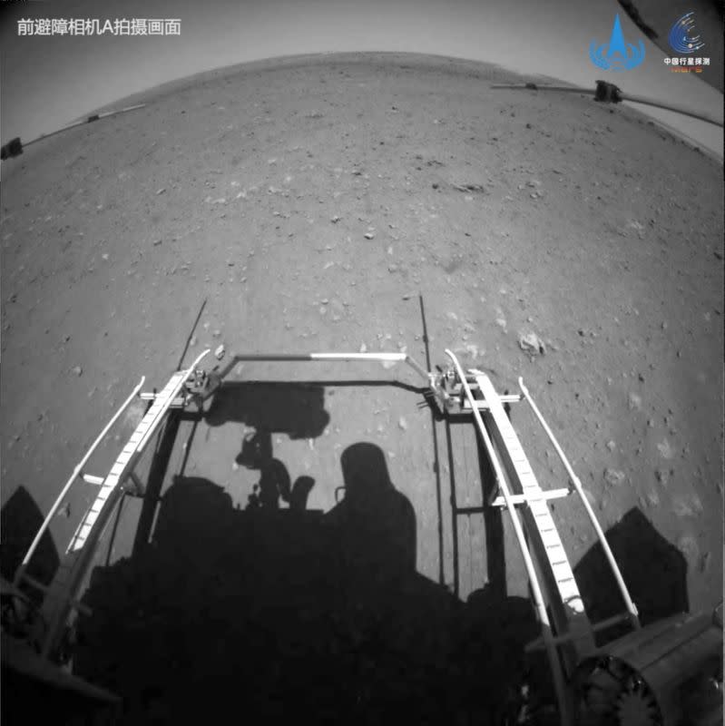 Handout image of Chinese rover Zhurong of the Tianwen-1 mission driving down the ramp of the lander onto the surface of Mars