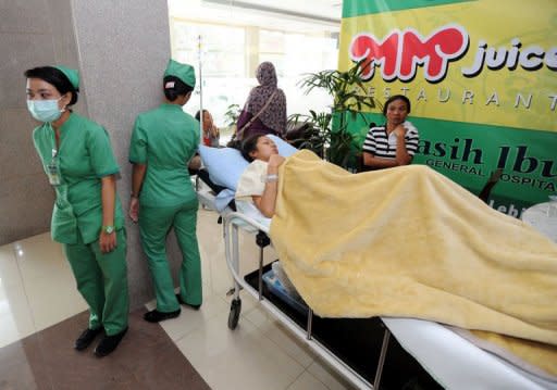 A patient rests in the corridor of the first floor of Kasih Ibu hospital in Denpasar after being transferred from the fourth floor after an earthquake rocked Indonesian's resort island of Bali on October 13, 2011 causing panic at the hospital and elsewhere