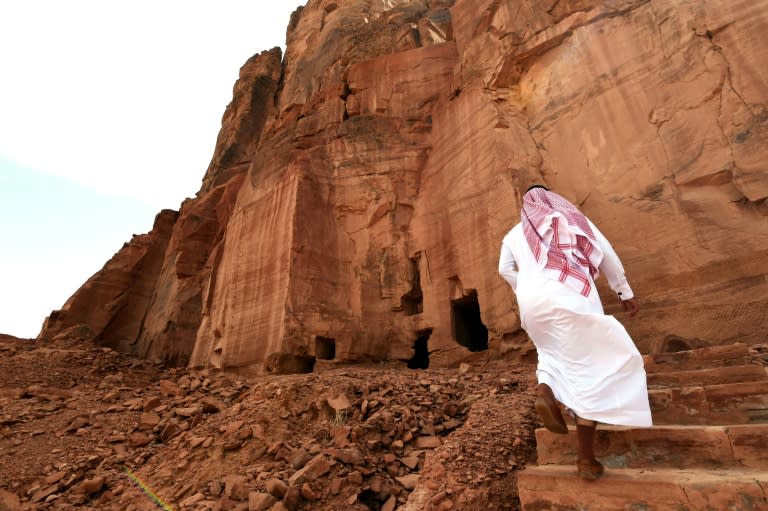 A man walks near ancient tombs at the Al-Khoraiba archaeological site in Saudi Arabia on March 31, 2018