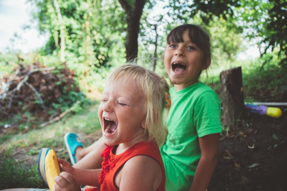 blond happy smiling little girl excited laugh hands in mouth