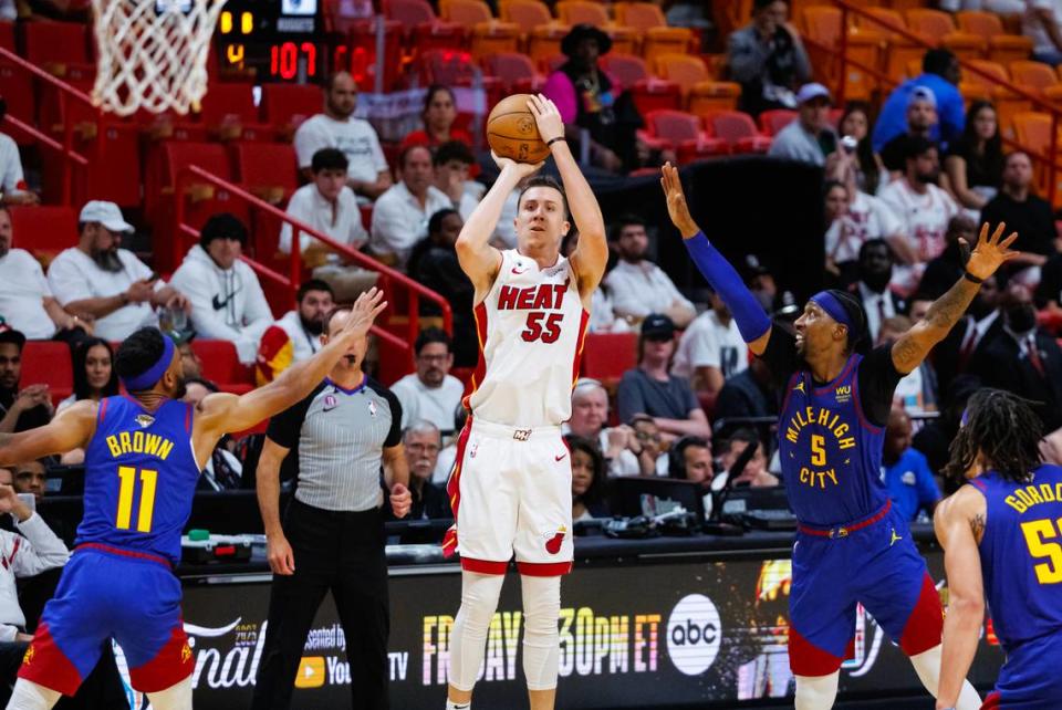 Miami Heat forward Duncan Robinson (55) take a shot against the defense of Denver Nuggets forward Bruce Brown (11) and Nuggets guard Kentavious Caldwell-Pope (5) during the second half of Game 3 of the NBA Finals at the Kaseya Center on Wednesday, June 7, 2023, in Miami, Florida.