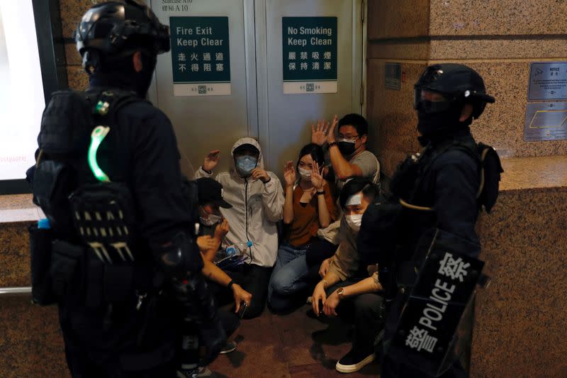 FILE PHOTO: People are detained by riot police during a march against the national security law on the anniversary of Hong Kong's handover to China from Britain in Hong Kong