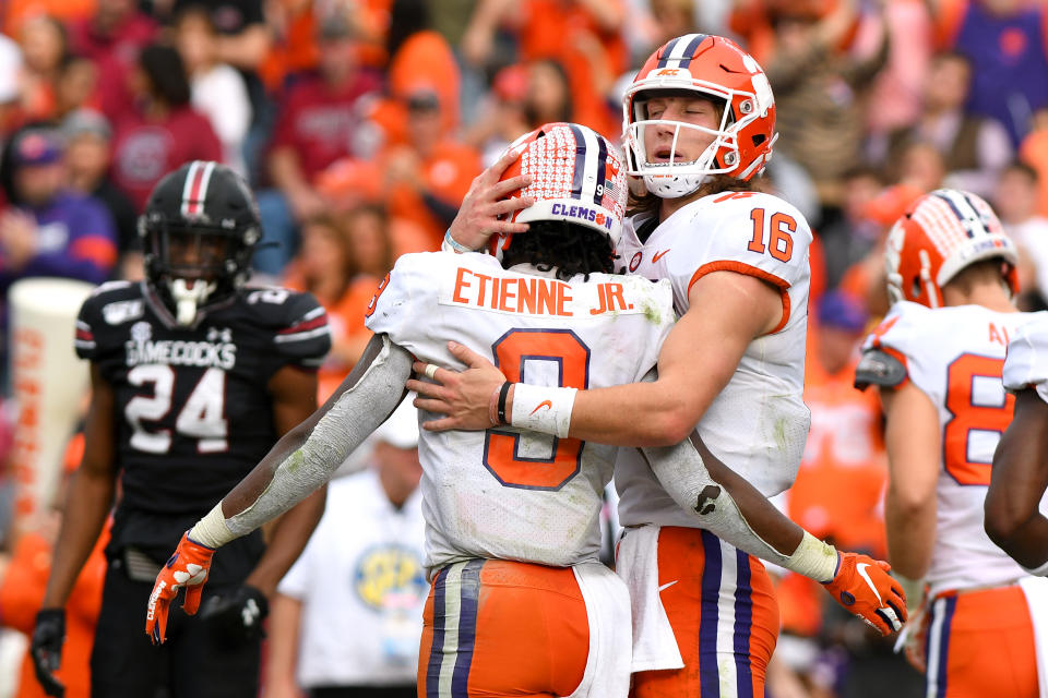 Clemson Tigers QB Trevor Lawrence (16) celebrates after Clemson Tigers RB Travis Etienne (9) scores a touchdown against the South Carolina Gamecocks. (Dannie Walls/Getty Images)