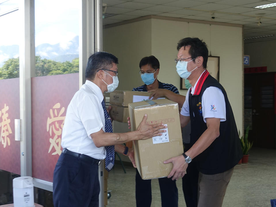 慈濟6月12日提供花蓮縣衛生局快篩試劑、N95口罩各5千個，副執行長劉效成(左)與衛生局長朱家祥(右)一起協助搬運物資。