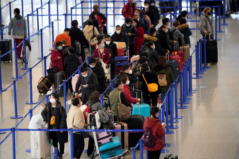 FILE PHOTO: Passengers wearing masks are seen at the Pudong International Airport in Shanghai