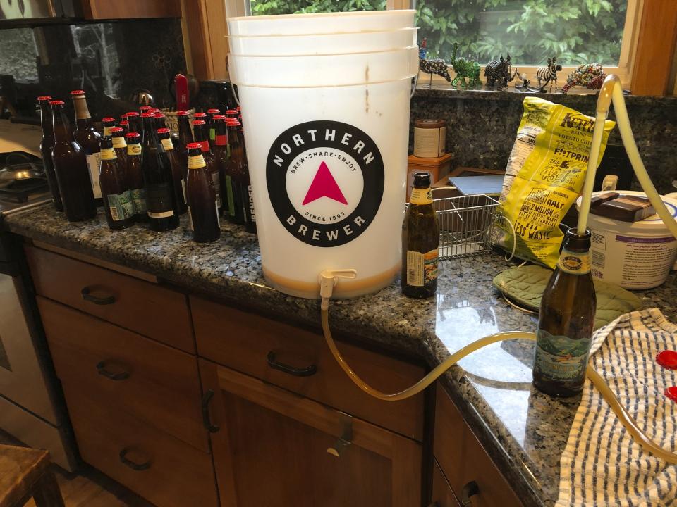 This March 28, 2020 photo shows home-brewed beer being bottled in Salem, Ore. Homebrewing provides an escape from dwelling on the COVID-19 pandemic. (AP Photo/Andrew Selsky)