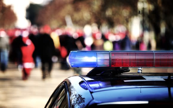 A flashing police siren escort during a demonstration through the streets of a city.