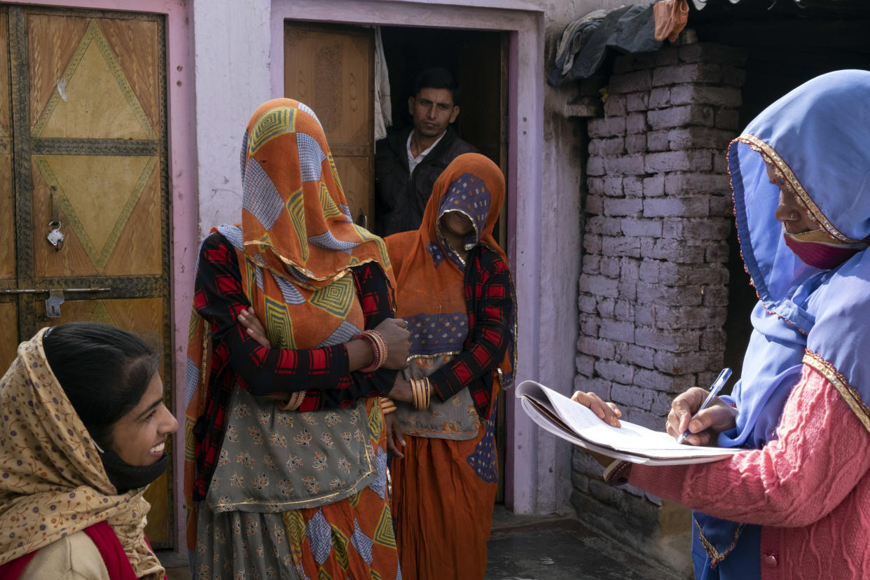 Bhanwar Bai Jadoun, a la derecha, una activista social sanitaria acreditada, y Anita Chowdhary, a la izquierda, actualizan los registros de vacunación de los niños en Bagdoli, India, el 10 de febrero de 2022. (Saumya Khandelwal/The New York Times).