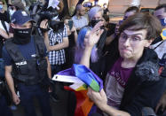 Activist Malgorzata Szutowicz, right, known as Margot, confronts police before being arrested in Warsaw, Poland, on Friday Aug. 7, 2020. LGBT rights activists scuffled with police Friday in Warsaw after turning out on the streets to protest the arrest of an an activist. According to Polish media reports, the activist was placed under two-months arrest Friday for protest actions against anti-homosexual attitudes. After the person was arrested in central Warsaw, protesters surrounded the police car and one person climbed on top of it. (AP Photo/Czarek Sokolowski)