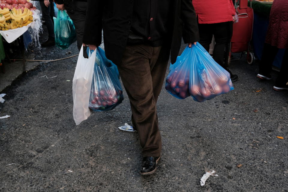 A man carries his shopping bags at a street market in Istanbul, Turkey, January 4, 2022. REUTERS/Murad Sezer