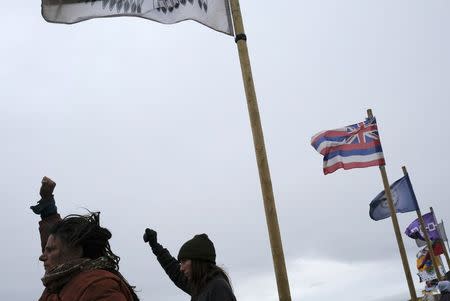 Dakota Access pipeline protesters walk near a row of tribal nation flags after a demonstration near the Dakota Access pipeline construction site north of Cannon Ball, North Dakota, U.S. October 29, 2016. REUTERS/Josh Morgan