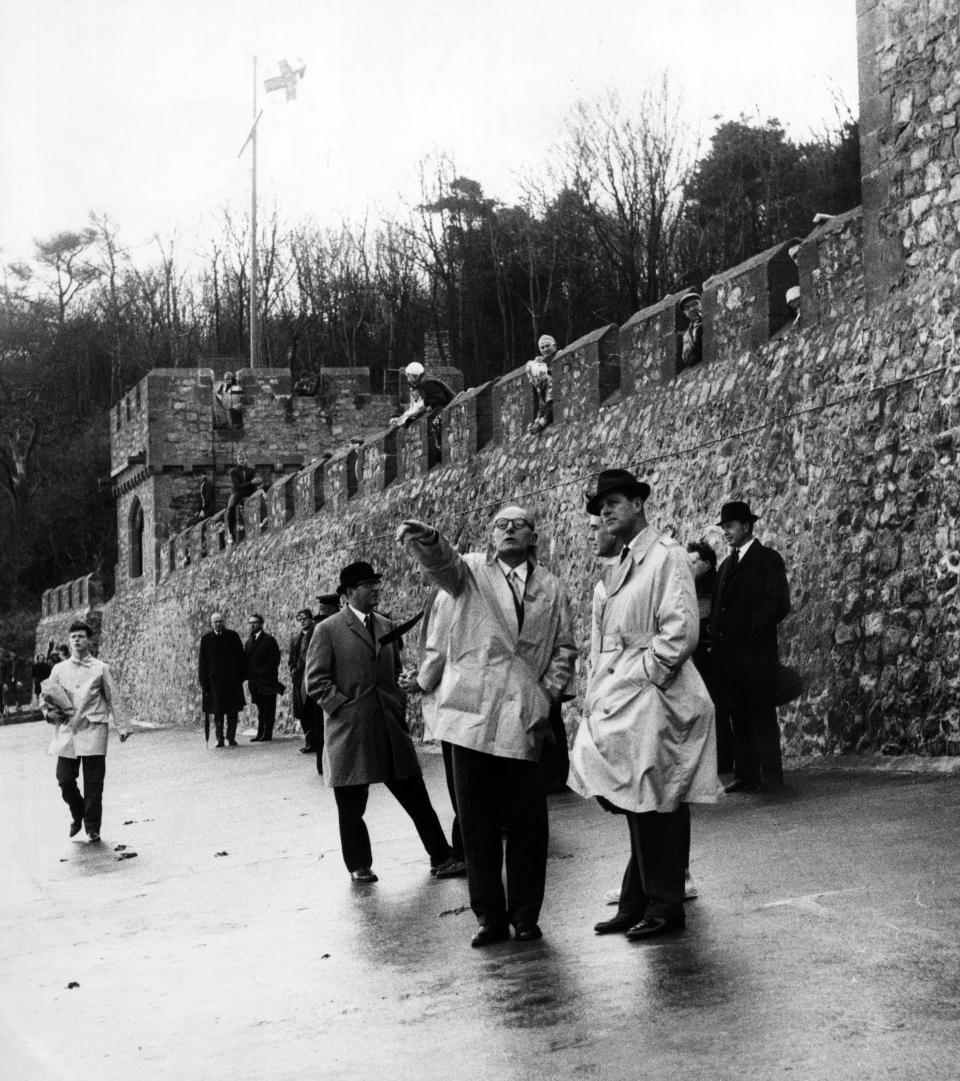 Prince Philip visiting Wales. Rear Admiral D J Hoare the headmaster of the Atlantic College points out features of the South Wales coastline to the Duke of Edinburgh. Behind them battlements of St Donat's Castle, with boys. November 1963. (Photo by Staff/Mirrorpix/Getty Images)