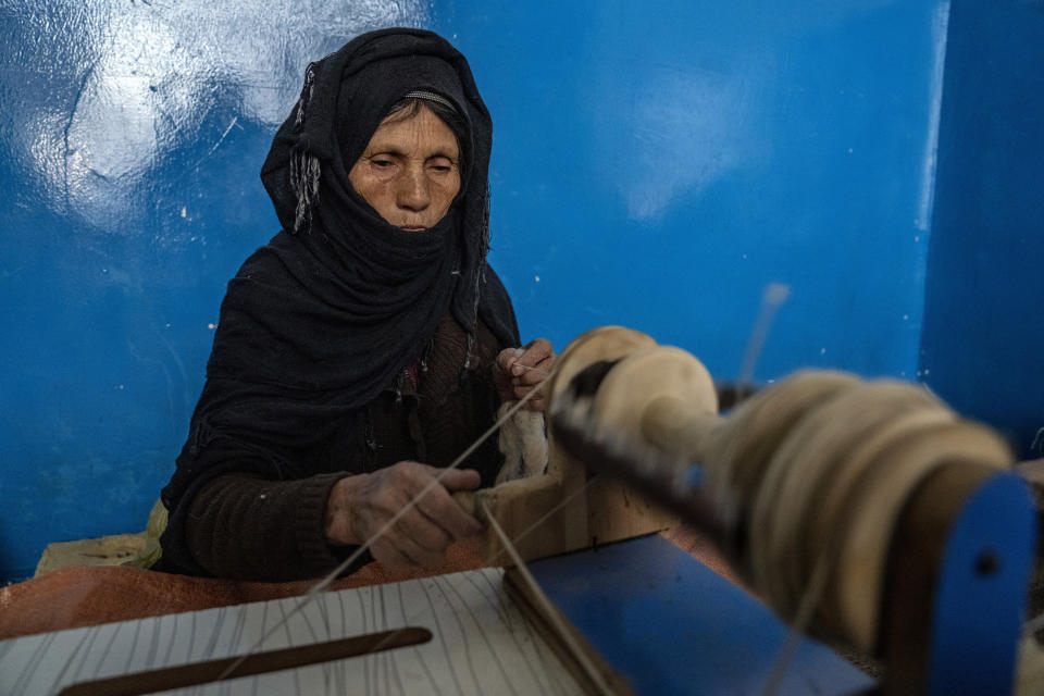 An Afghan woman weaves wool for making carpets at a traditional carpet factory in Kabul, Afghanistan, Sunday, March 5, 2023. After the Taliban came to power in Afghanistan, women have been deprived of many of their basic rights. (AP Photo/Ebrahim Noroozi)