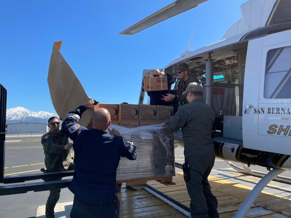 Personnel from the San Bernardino County Sheriff's and SBC Fire departments load food onto a sheriff's helicopter, which will be delivered to mountain residents.