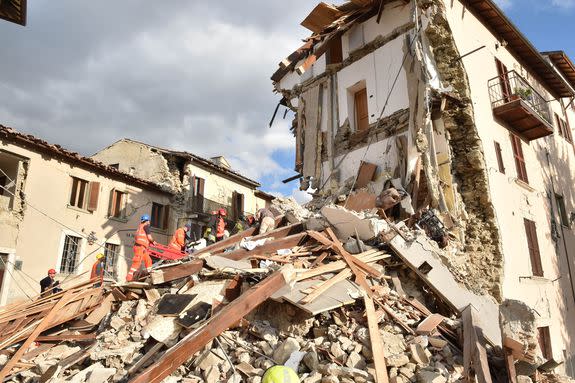 Rescuers clear debris while searching for victims in damaged buildings  in Arquata del Tronto, Italy, Aug. 24, 2016.