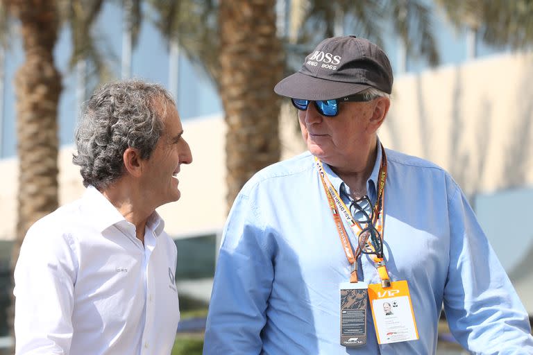 John Watson (derecha) habla con un ex compañero, el tetracampeón Alain Prost; el norirlandés analizó los problemas de espalda de Lewis Hamilton y cuestionó al piloto de Mercedes.