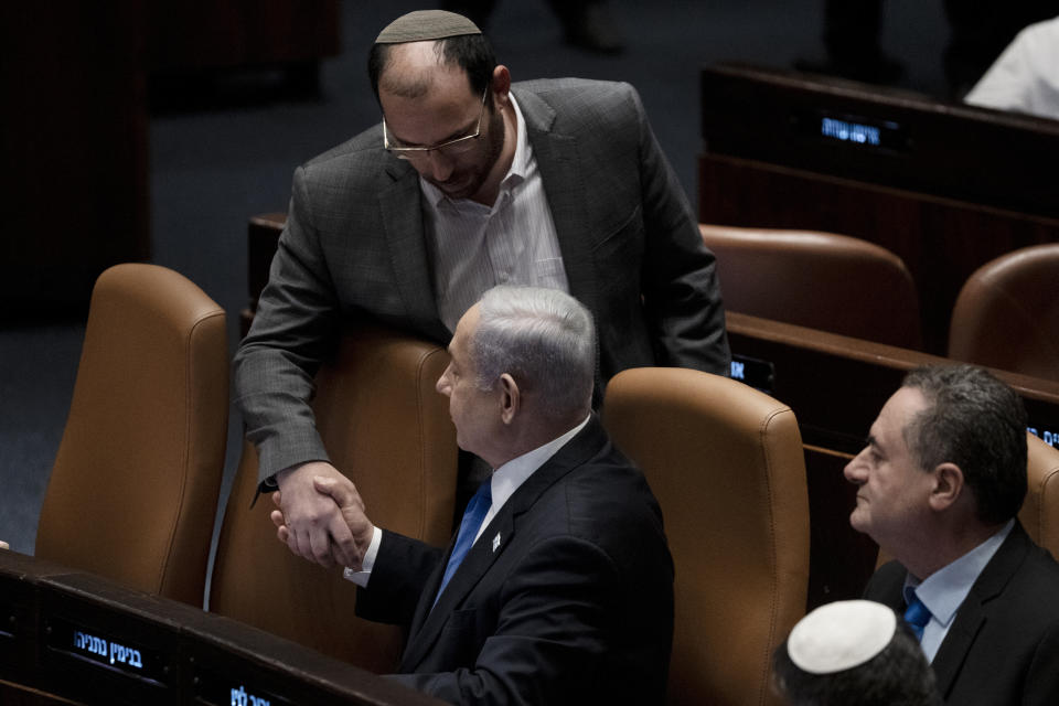 Lawmaker Simcha Rothman, top, shakes hands with Israel's Prime Minister Benjamin Netanyahu at a session of the Knesset, Israel's parliament, in Jerusalem, Monday, July 24, 2023. (AP Photo/Maya Alleruzzo)