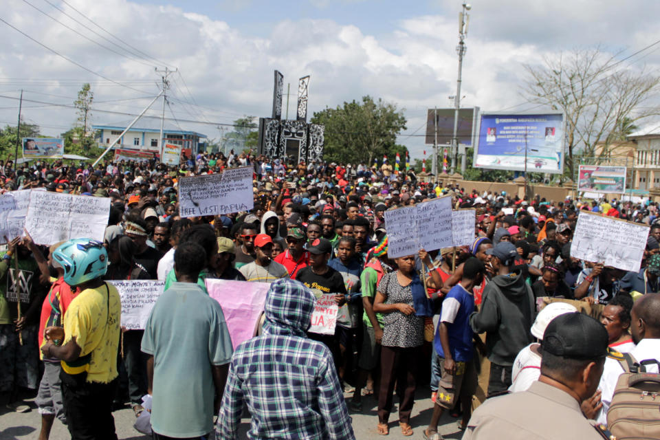 Papuans hold posters during a protest in Timika, Papua province, Wednesday, Aug. 21, 2019. Indonesia has deployed over 1,000 security personnel to the restive province of West Papua amid spreading violent protests sparked by accusations that security forces had arrested and insulted Papuan students in East Java . (AP Photo/Jimmy Rahadat)