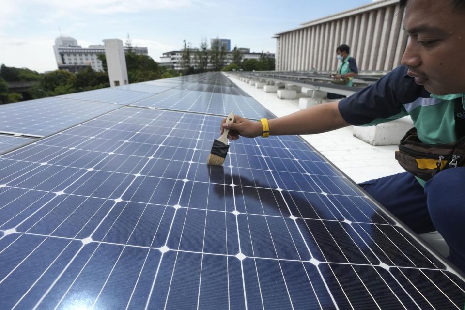 Workers perform maintenance work on solar panels that provide partial electrical power to Istiqlal Mosque in Jakarta, Indonesia,Wednesday, March 29, 2023. A major renovation in 2019 installed upwards of 500 solar panels on the mosque's expansive roof, now a major and clean source of Istiqlal's electricity. (AP Photo/Tatan Syuflana)