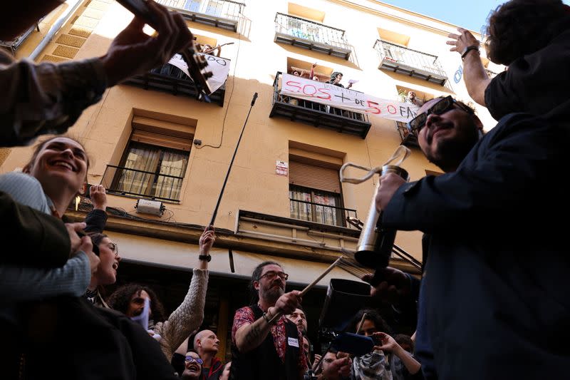 Artists perform during a protest action outside a building whose residents fear they will be evicted in the event of its purchase by a real estate investment fund, in Madrid