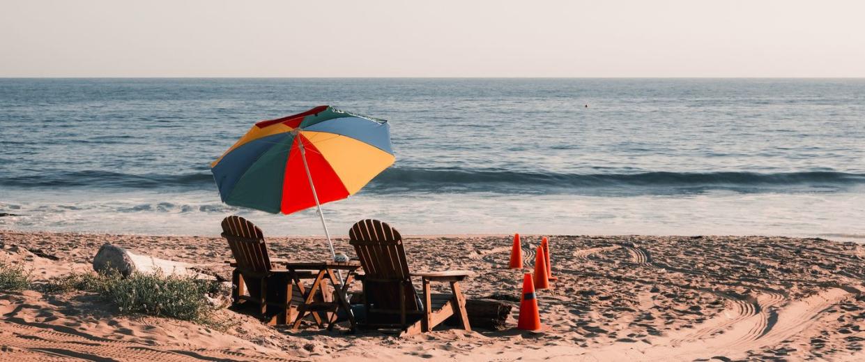 couple sitting on chair at beach against clear sky,crystal cove state park,united states,usa