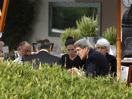 U.S. Secretary of State John Kerry (2nd R) and Russian Foreign Minister Sergei Lavrov (back to camera) negotiate ongoing problems in Syria, while seated with their senior aides by the swimming pool at a hotel in Geneva September 14, 2013. REUTERS/Larry Downing