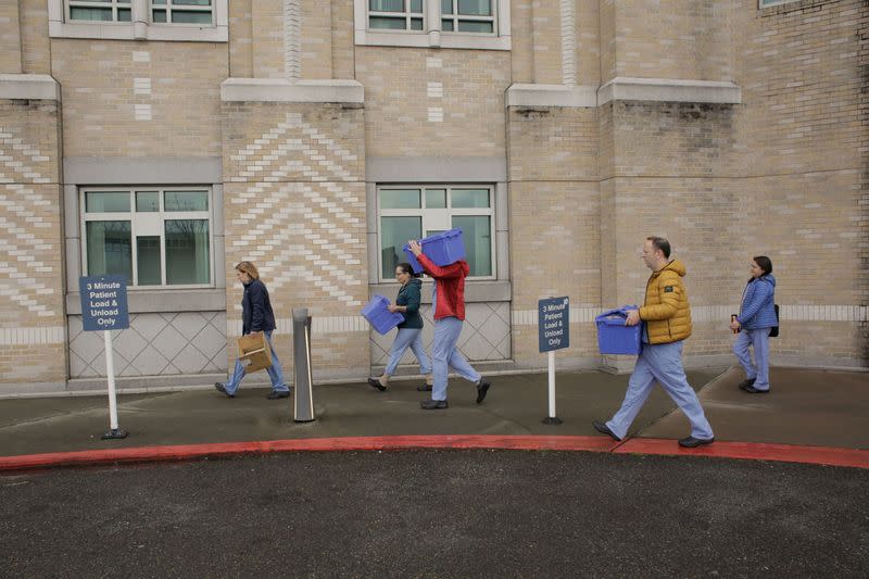 Harborview Medical Center’s home assessment team carry protective and testing supplies while preparing to visit the home of a person potentially exposed to novel coronavirus at Harborview Medical Center in Seattle