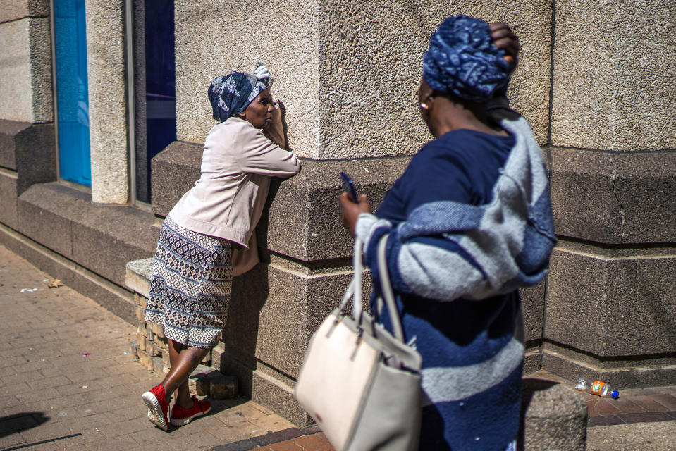 A South African woman rests on a wall after being denied her informal vendor's permit in Johannesburg, Tuesday, April 7, 2020. South Africa and more than half of Africa's 54 countries have imposed lockdowns, curfews, travel bans or other restrictions to try to contain the spread of COVID-19. The new coronavirus causes mild or moderate symptoms for most people, but for some, especially older adults and people with existing health problems, it can cause more severe illness or death.(AP Photo/Jerome Delay)