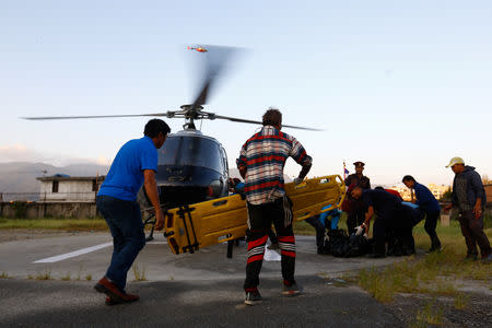 ATTENTION EDITORS - VISUAL COVERAGE OF SCENES OF INJURY OR DEATH Nepalese trekking staff and police officers move the dead bodies of South Korean and Nepali climbers at the helipad of the Teaching Hospital in Kathmandu, Nepal, October 14, 2018. Picture taken October 14, 2018. REUTERS/Sulav Shrestha