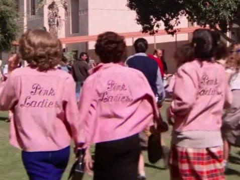 the back of three students wearing pink lady jackets