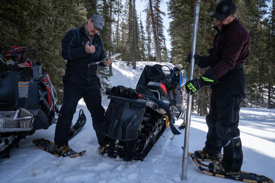 Wade Payne (right) readies the core snow sample tube, while his brother Kevin Payne waits to calculate the snow water equivalent on March 25, 2022, at Horse Creek, west of Pinedale, Wyoming.