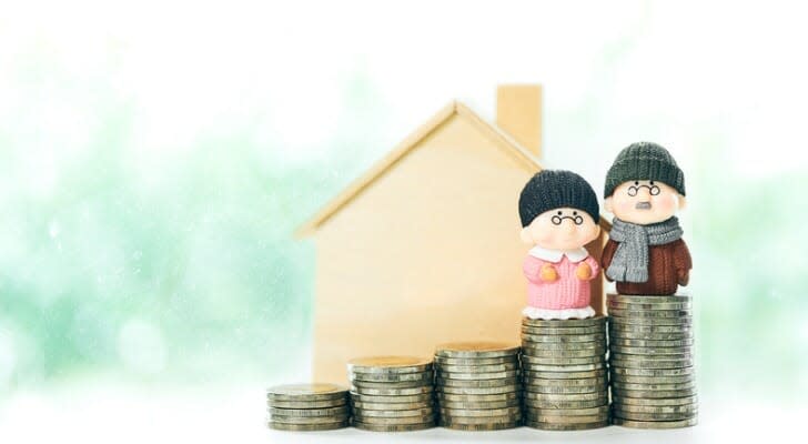 elderly couple dolls on top of a stack of coins