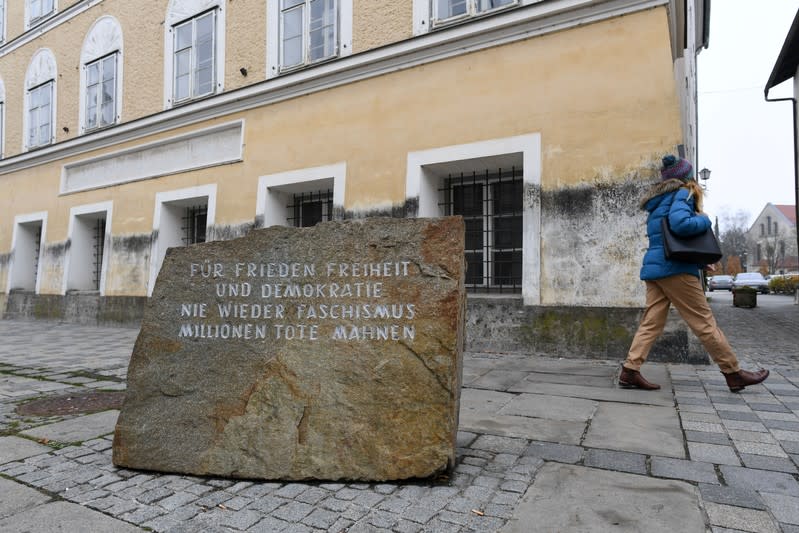 A woman walks past a memorial in front of Adolf Hitler's birth-house in Braunau