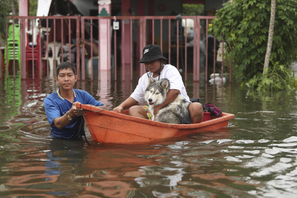 Thai resident wade through floodwaters, Thursday, Sept. 29, 2022, in Ubon Ratchathani province, northeastern Thailand. Heavy rains and strong winds from tropical storm Noru swept across parts of northeastern Thailand on Thursday morning, knocking down trees and triggering flash floods in several areas. (AP Photo/Nava Sangthong)