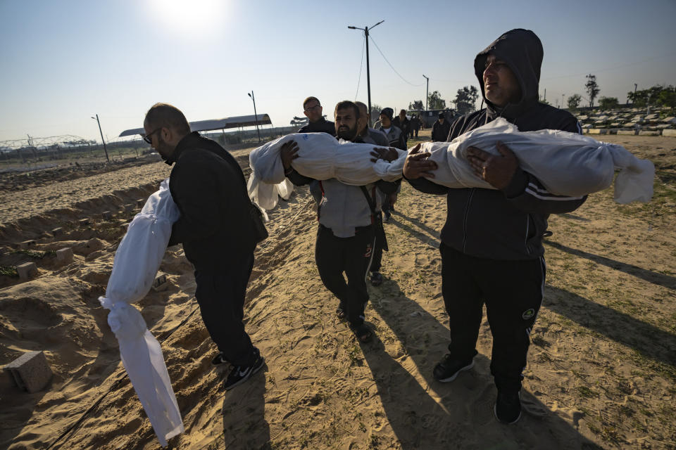 Palestinians bury their relatives killed in the Israeli bombardment of the Gaza Strip, at a cemetery in Rafah, southern Gaza, Tuesday, Dec. 19, 2023. (AP Photo/Fatima Shbair)