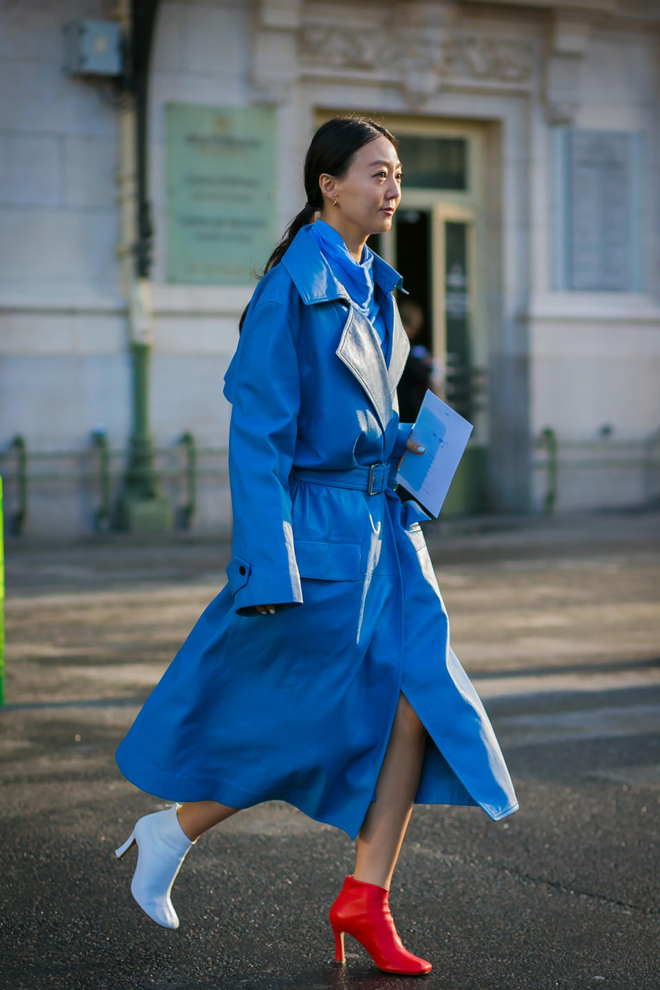 An Olivier Theyskens showgoer models the same trend in vibrant blue — with mismatched booties and extra-long sleeves adding just the right amount of off-kilter to her look.