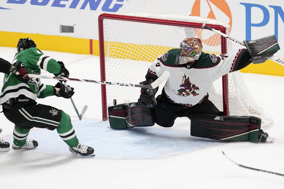 Dallas Stars center Matt Duchene, left, scores against Arizona Coyotes goaltender Karel Vejmelka in overtime of an NHL hockey game, Tuesday, Nov. 14, 2023, in Dallas. (AP Photo/Tony Gutierrez)