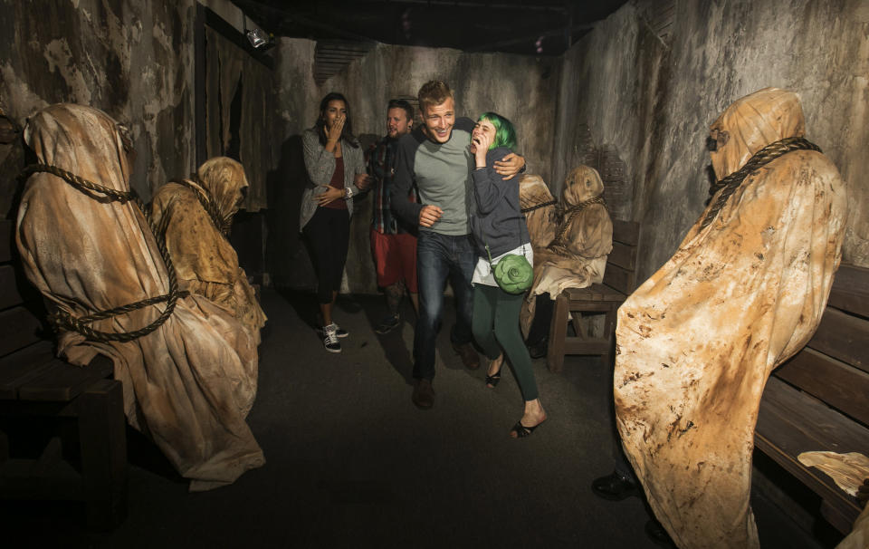 This Friday, Sept. 20, 2013 publicity photo released by Universal Studios Hollywood captures guests experiencing the "Insidious: Into the Further" maze based on the recent blockbuster film "Insidious: Chapter 2" during Halloween Horror Nights in Universal City, Calif. Several spooks at this year's Halloween Horror Nights are hyping new releases from the entertainment industry. Besides "13" from Sabbath, there's a "scare zone" populated by actors dressed as the nasty Chucky doll from the direct-to-DVD sequel "Curse of Chucky," and a new maze incorporating supernatural elements from the "Insidious" films. (AP Photo/Universal Studios Hollywood)
