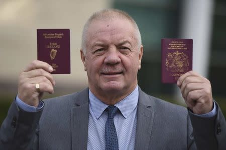 Raymond McCord displays his Irish and United Kingdon passports to media as he departs the High Court in Belfast, Northern Ireland October 28, 2016. REUTERS/Clodagh Kilcoyne