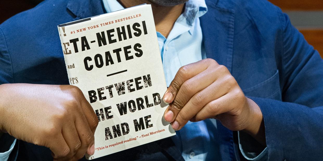 Ta-Nehisi Coates holding a copy of his 2015 memoir "Between the World and Me."